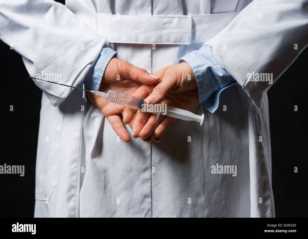Closeup on medical doctor woman hiding syringe behind back Stock Photo ...