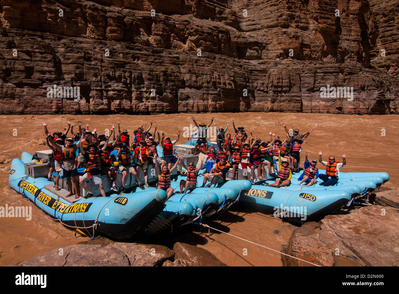 Happy tourists on two rafts celebrating, in the beautiful scenery of the Colorado River in the Grand Canyon, Arizona, USA Stock Photo