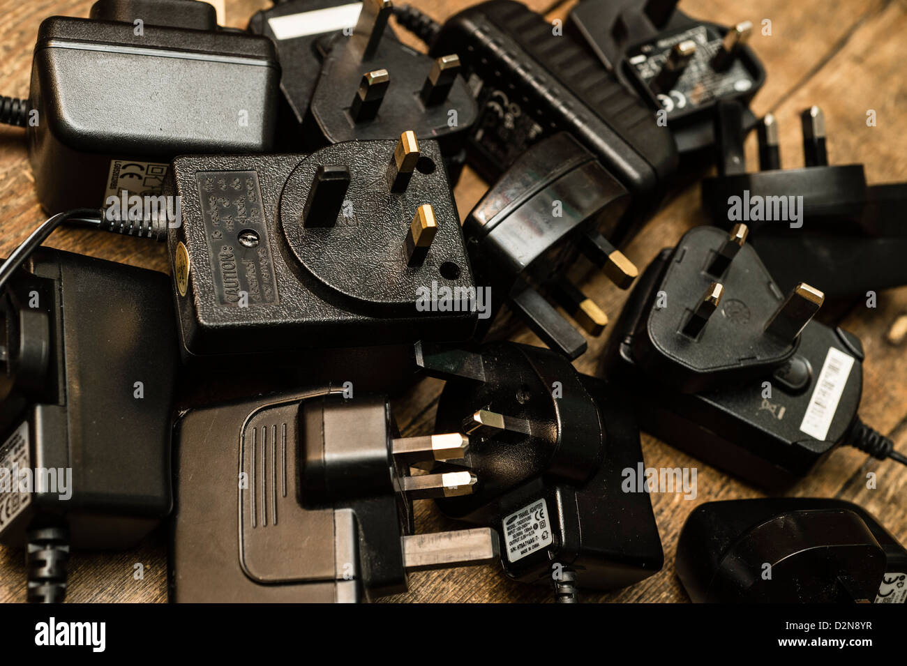 A pile of old redundant mobile phone chargers and other electrical power adaptors UK Stock Photo