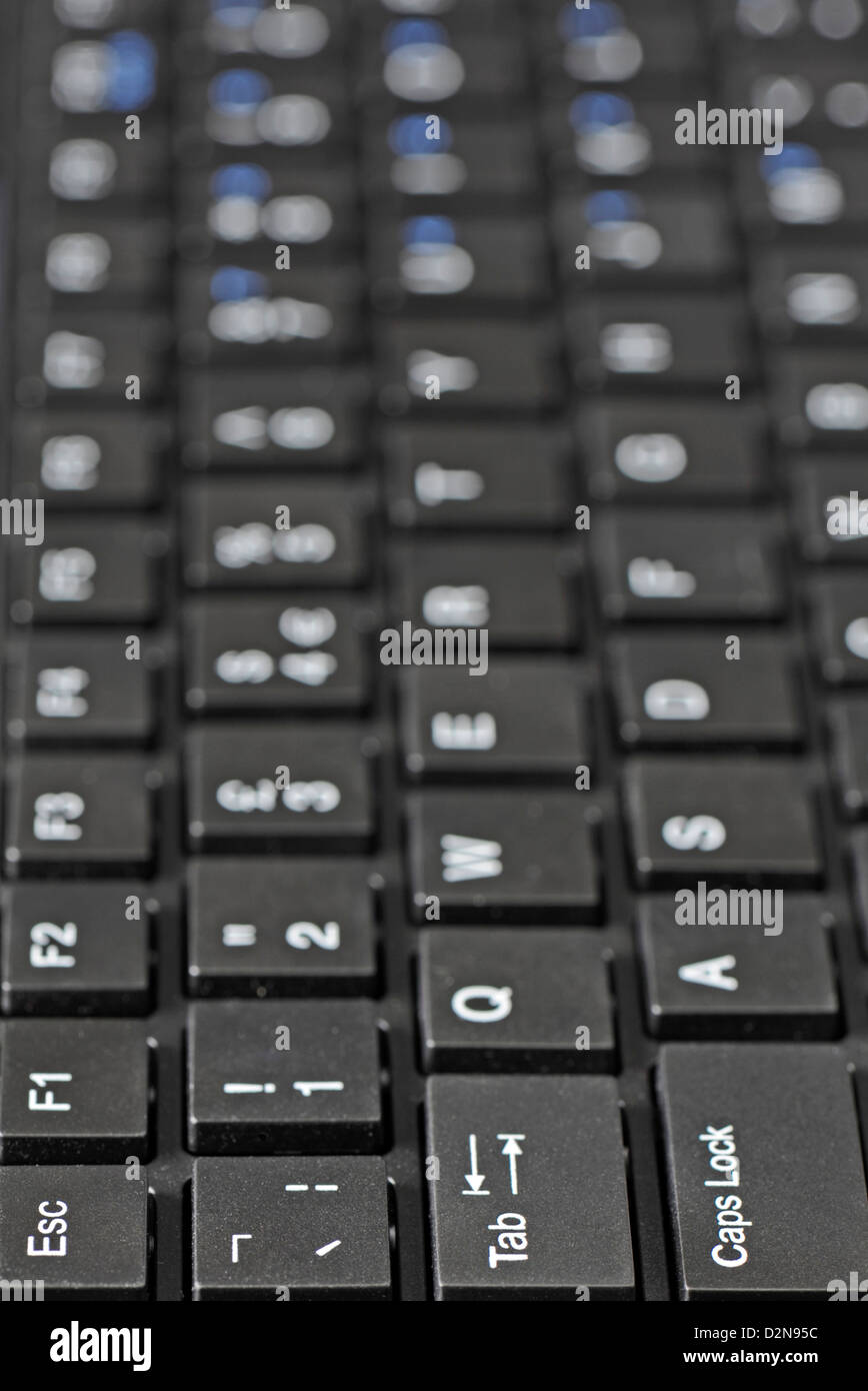 Close-up shot along the length of a computer keyboard with the focus on the left-hand end Stock Photo