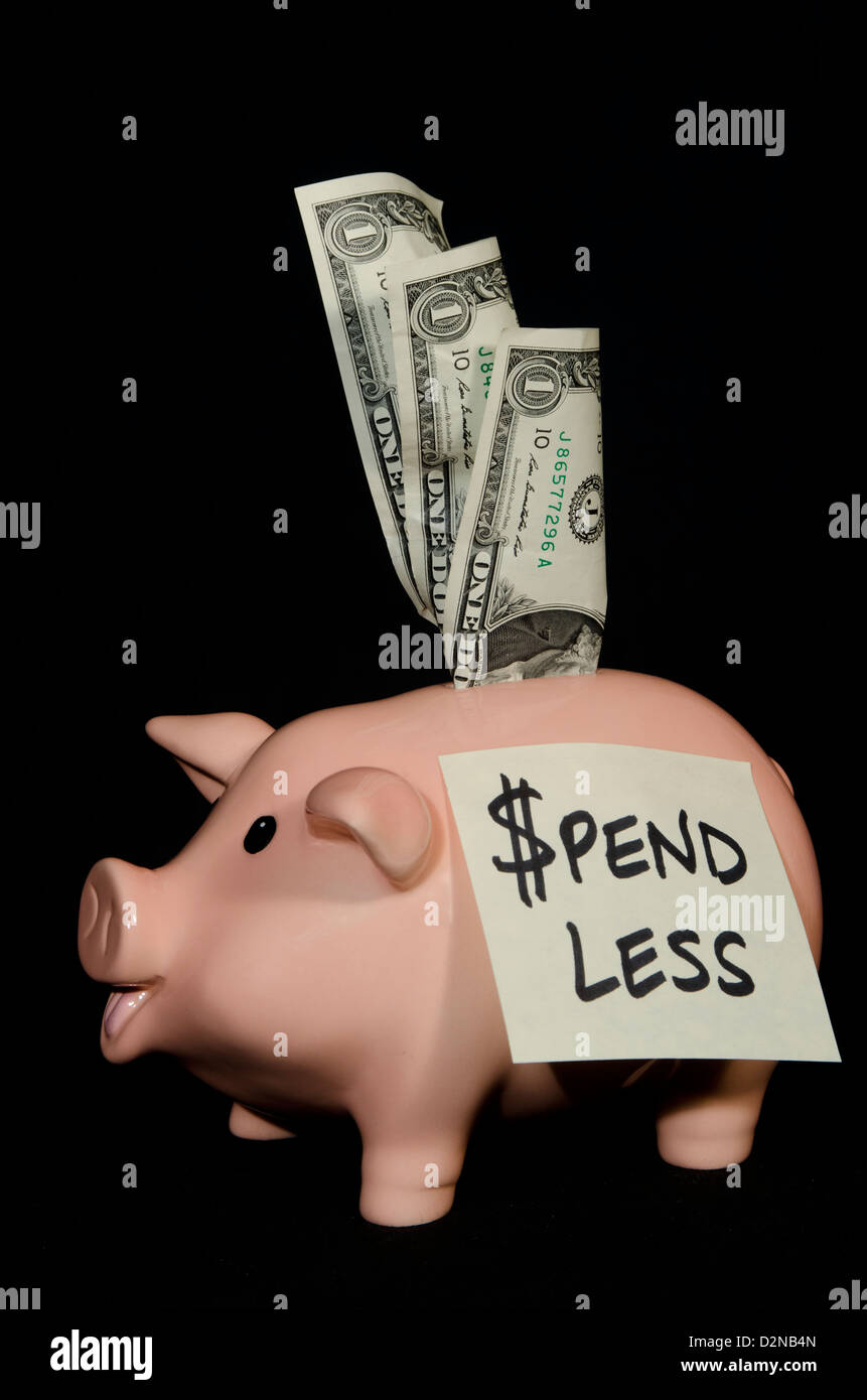 This little piggy bank has a note on his side to remind him to spend less money and try to save it. Stock Photo