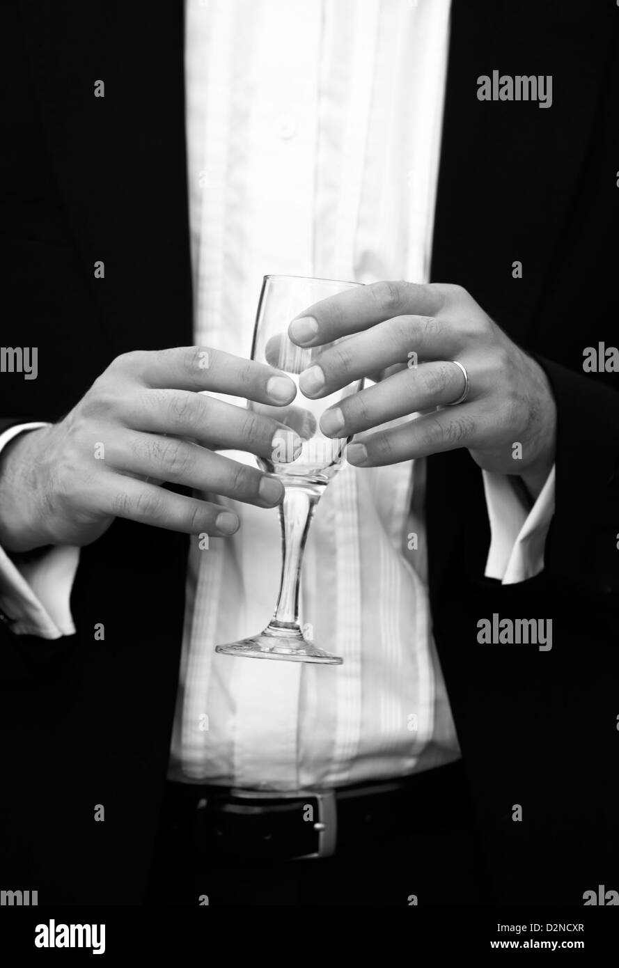 Glass of champagne in a hand of the groom Stock Photo