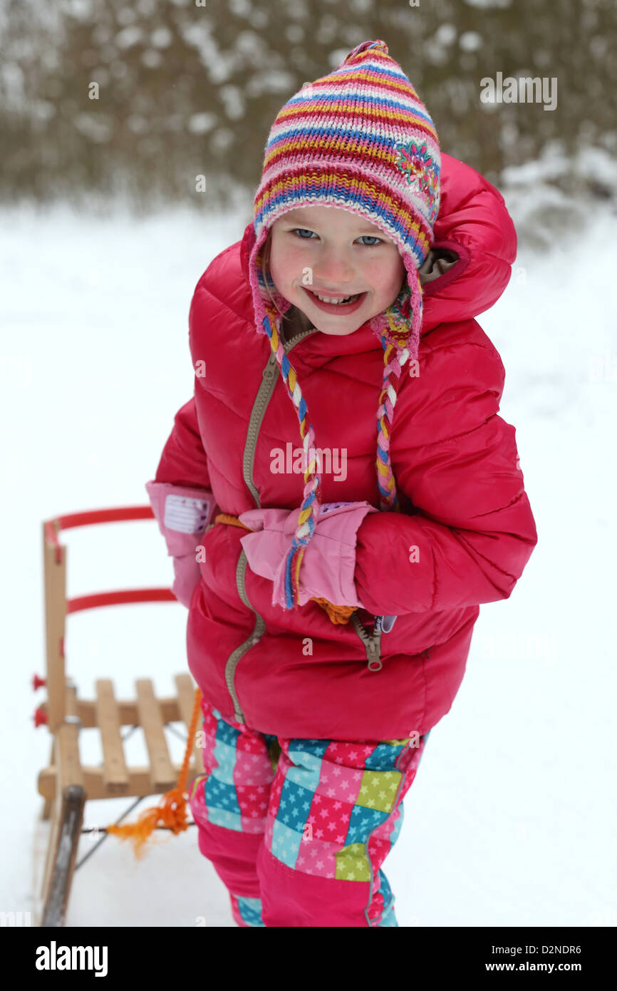 Young girl (4 years) pulling sled up snow covered hill in Dortmund, Germany Stock Photo