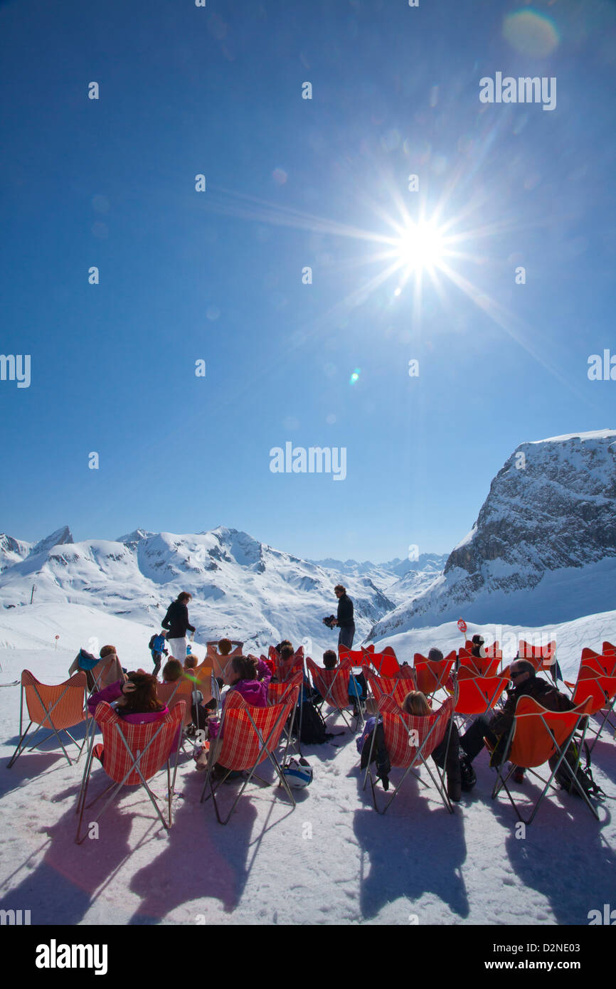 Skiers relaxing outside a mountain restaurant high above Zurs, Arlberg, Austria. Stock Photo