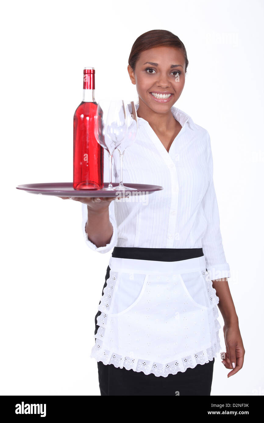 Young waitress with a bottle of rose wine and two glasses Stock Photo