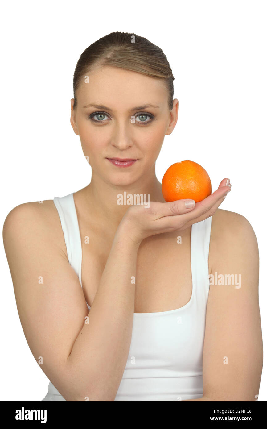 Young woman holding an orange Stock Photo - Alamy