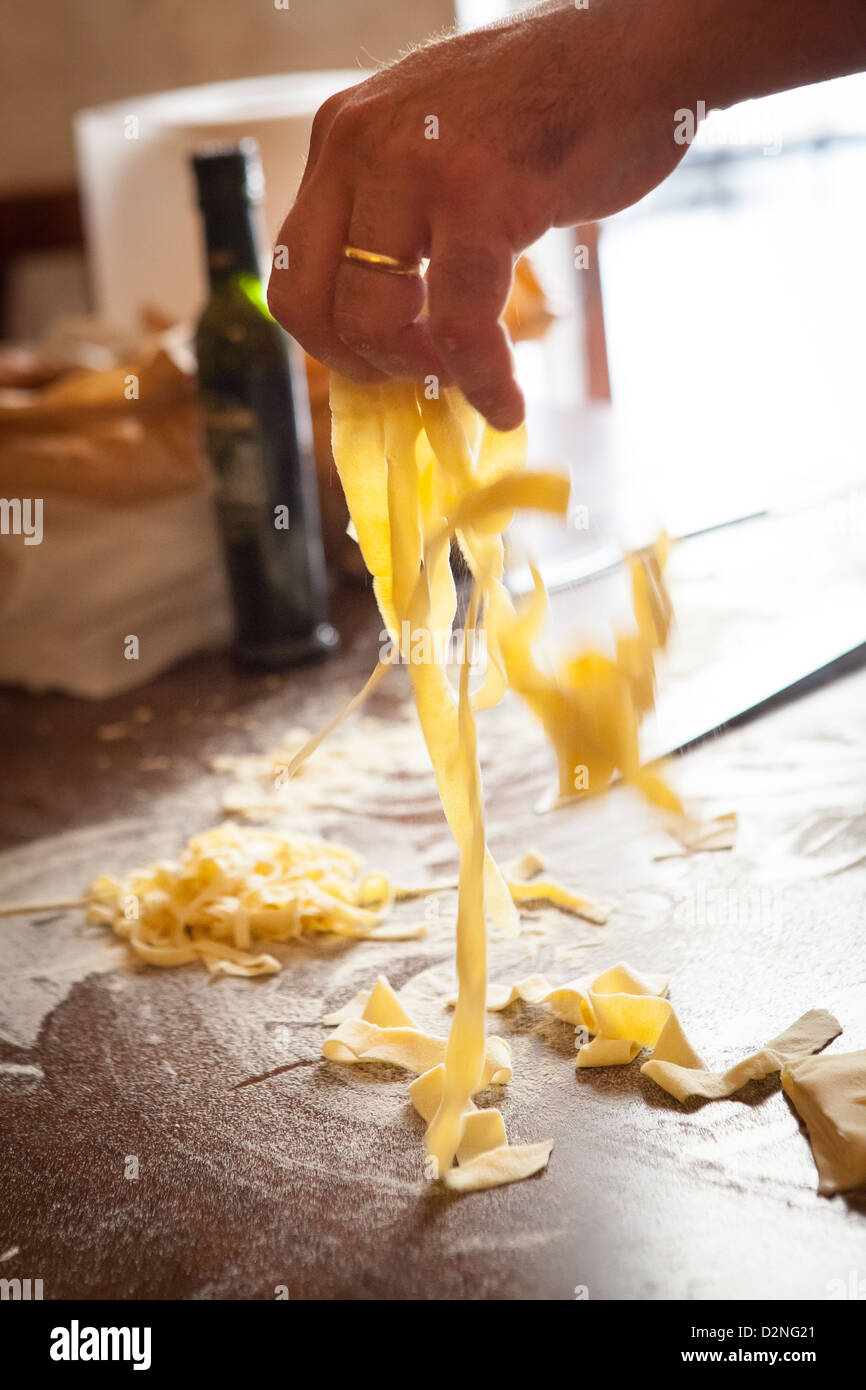 Shaking out egg free Tagliatelle pasta. Stock Photo