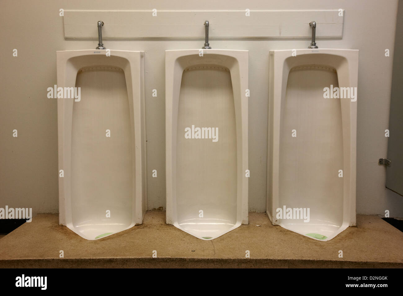 full length urinals in mens toilet of High school canada north america Stock Photo