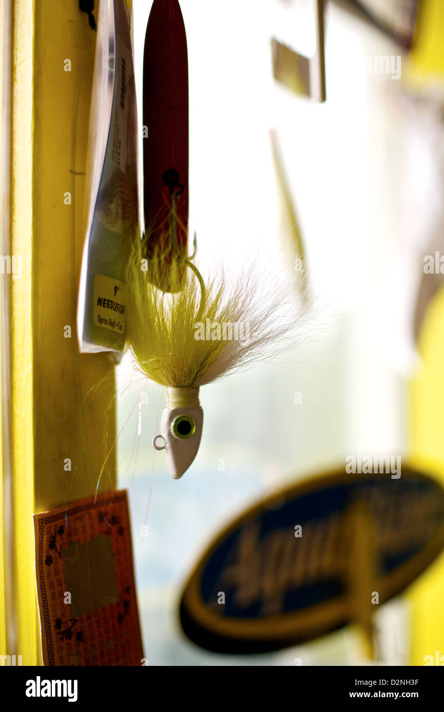 A fishing lure hangs from a hook in the window of a Montauk tackle shop