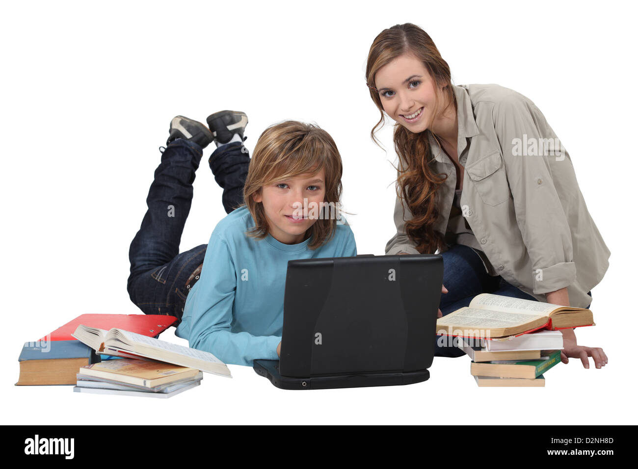 teenager doing his homework with laptop and elder sister Stock Photo