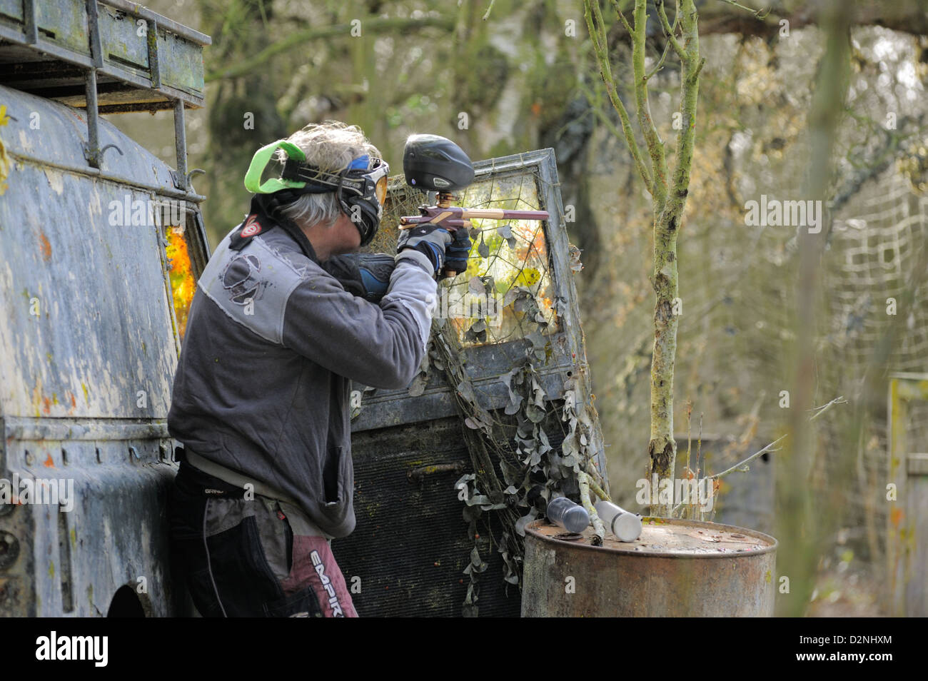 Man playing paintball behind a Landrover Stock Photo