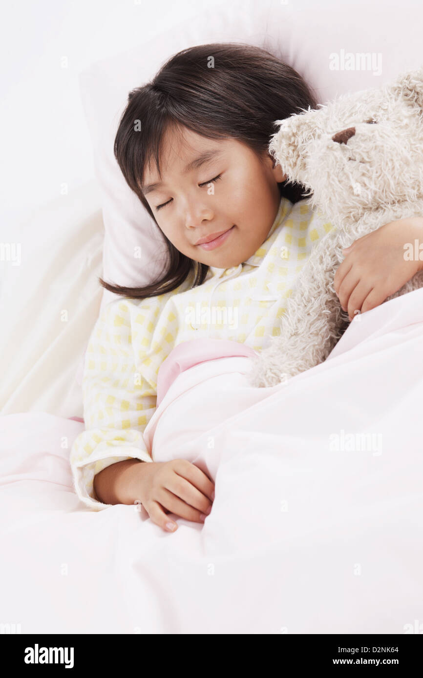 Girl sleeping in bed with a teddy bear Stock Photo - Alamy