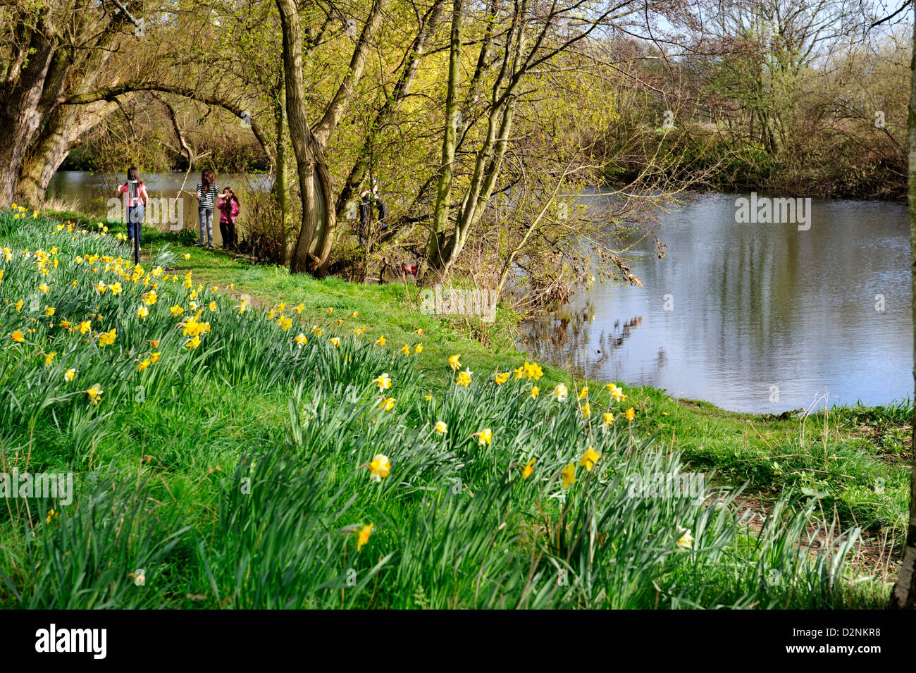 Children playing on river bank in spring Stock Photo