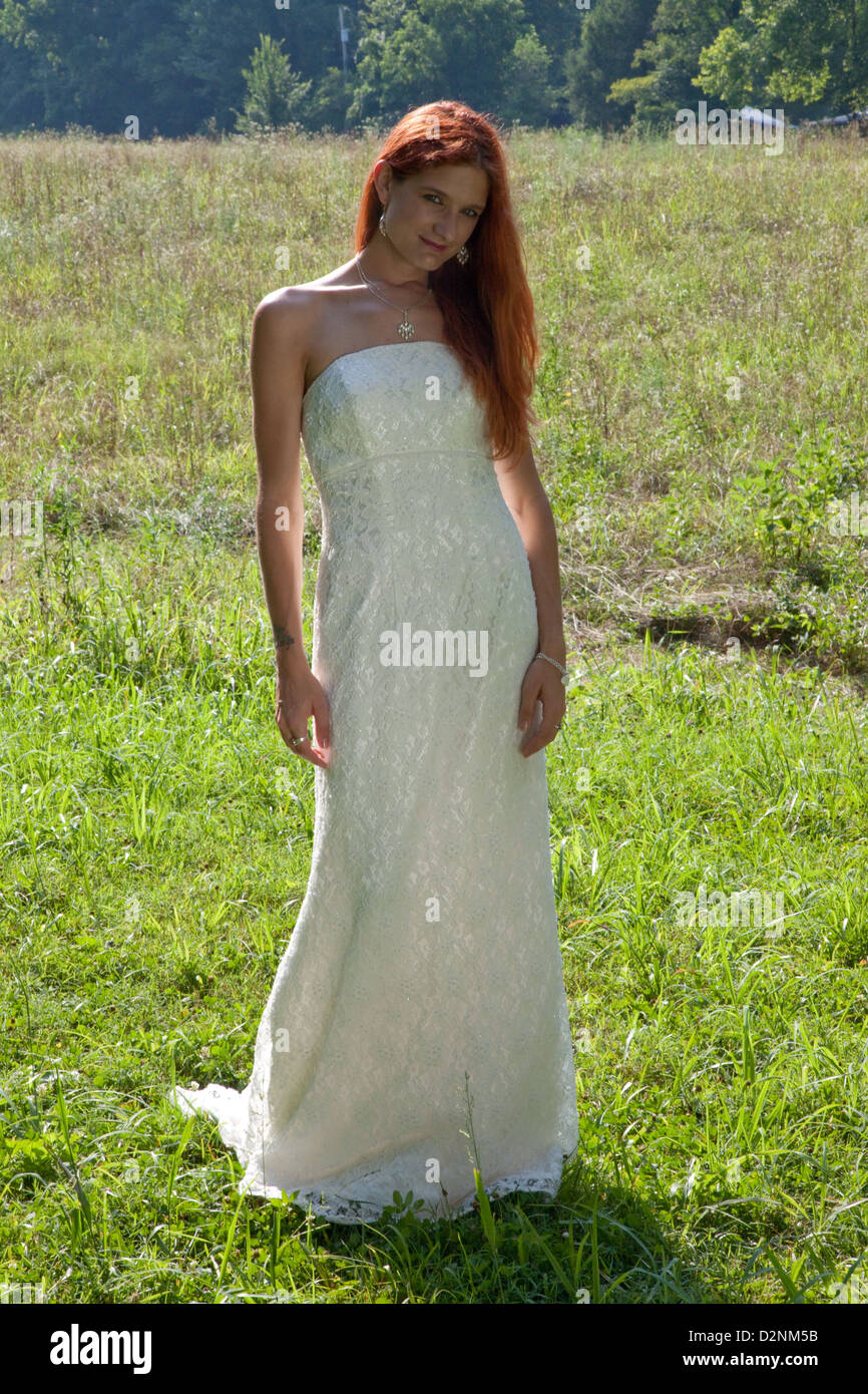 pretty-redhead-woman-wearing-a-wedding-dress-standing-in-a-field-in-D2NM5B.jpg