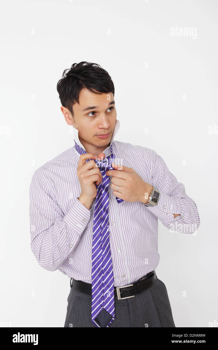 Businessman tying necktie Stock Photo - Alamy