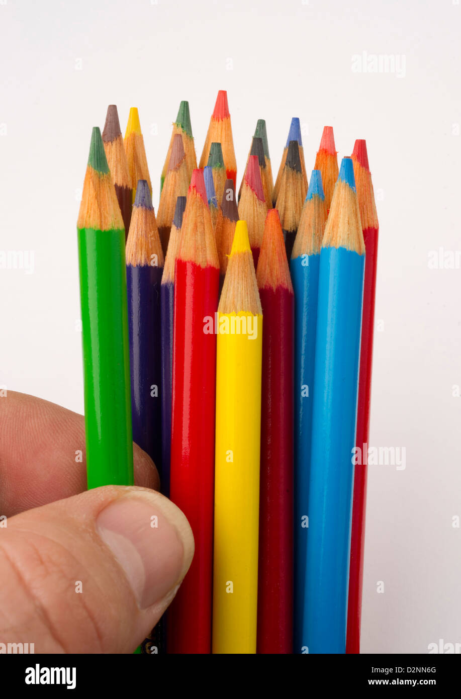 a green color pencil is chosen from a group of art supplies Stock Photo
