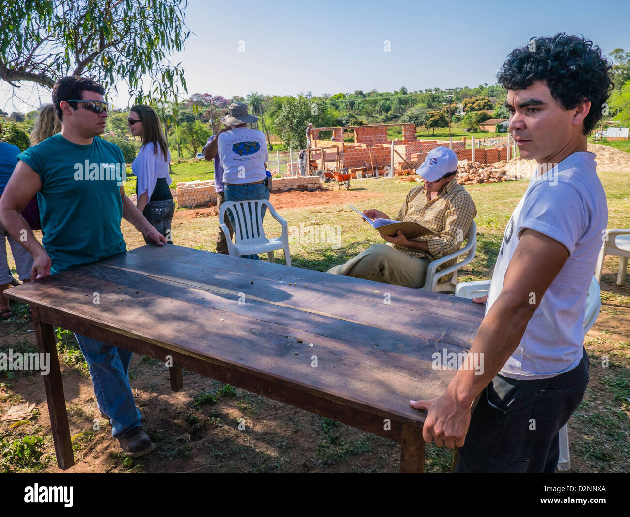 Adult volunteers for Habitat for Humanity at a ceremony for their work in building a house on the work site in Luque, Paraguay. Stock Photo