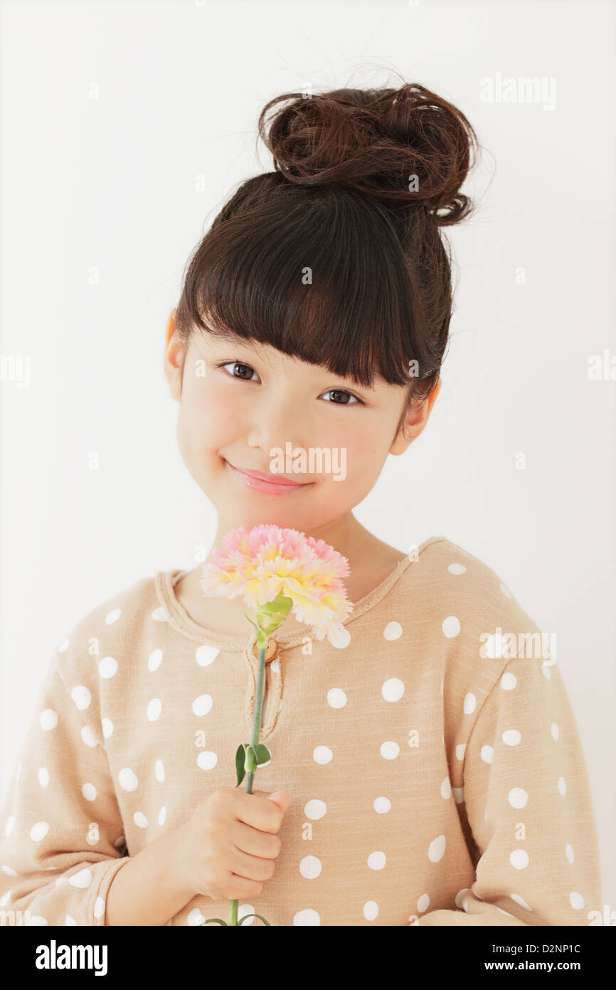 Young girl with flower smiling at camera Stock Photo - Alamy