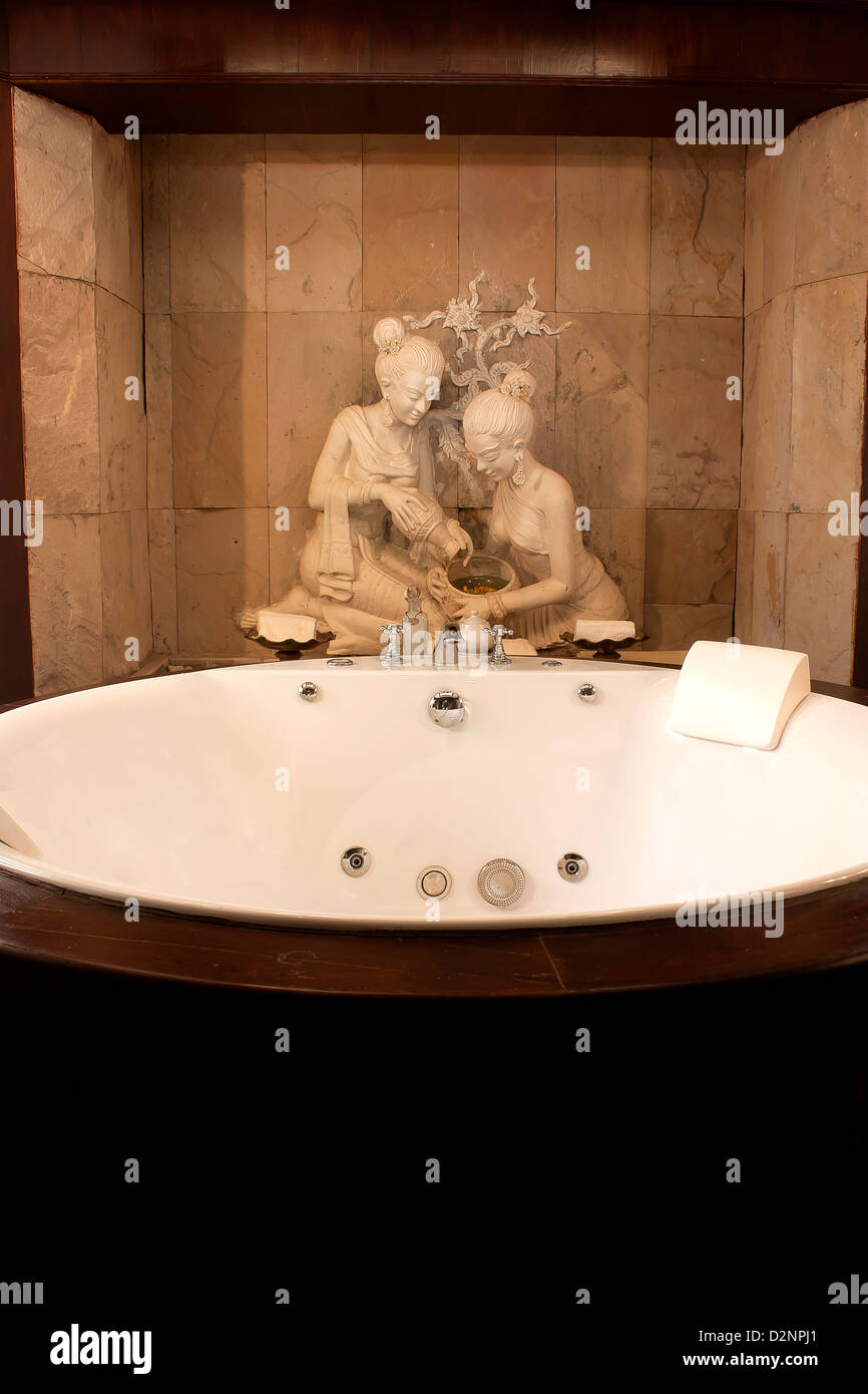 Jacuzzi tub in the room with the statue of ancient Thailand. Stock Photo