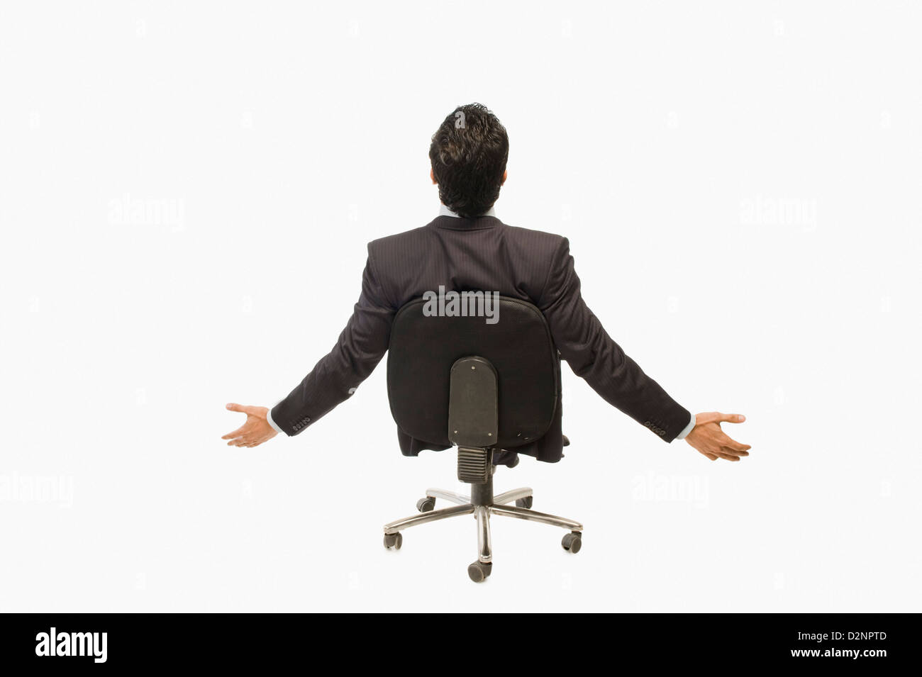 Businessman sitting on a chair with his arm outstretched Stock Photo