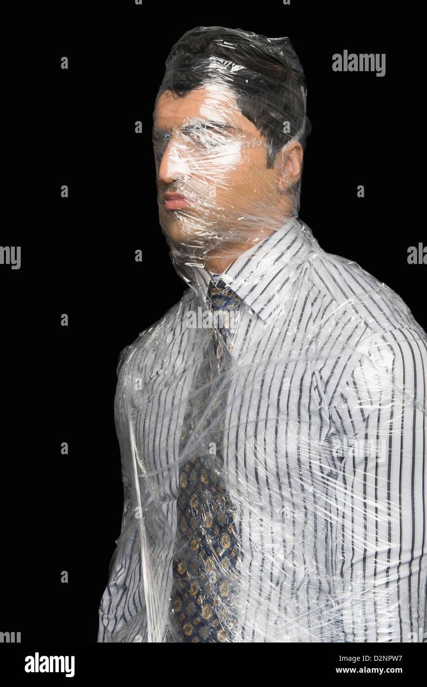 Businessman wrapped in a plastic wrap Stock Photo - Alamy