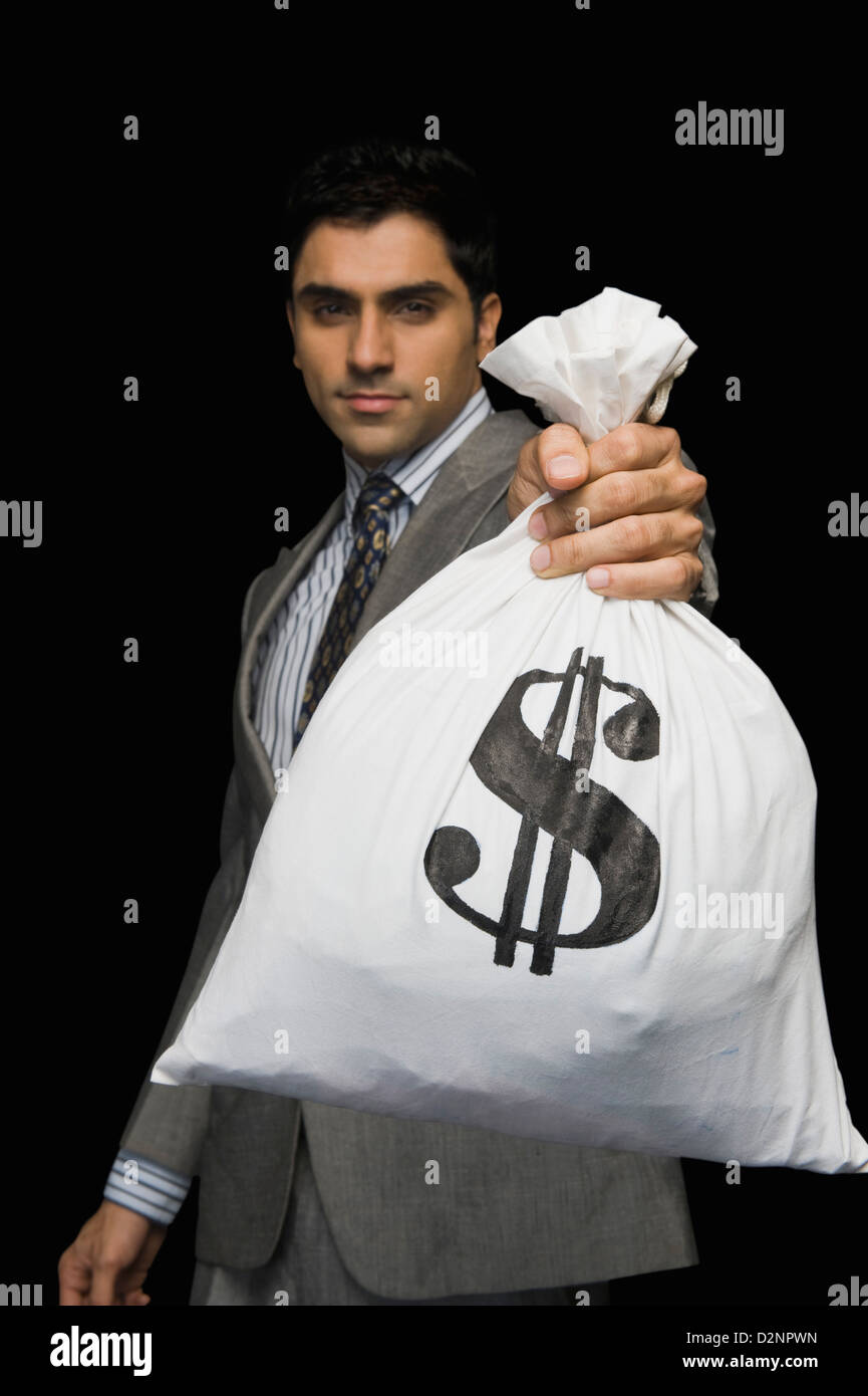 Businessman showing a money bag Stock Photo - Alamy