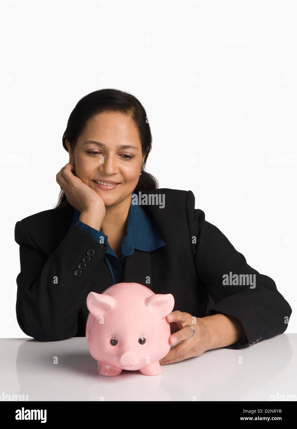 Businesswoman looking at a piggy bank and smiling Stock Photo - Alamy