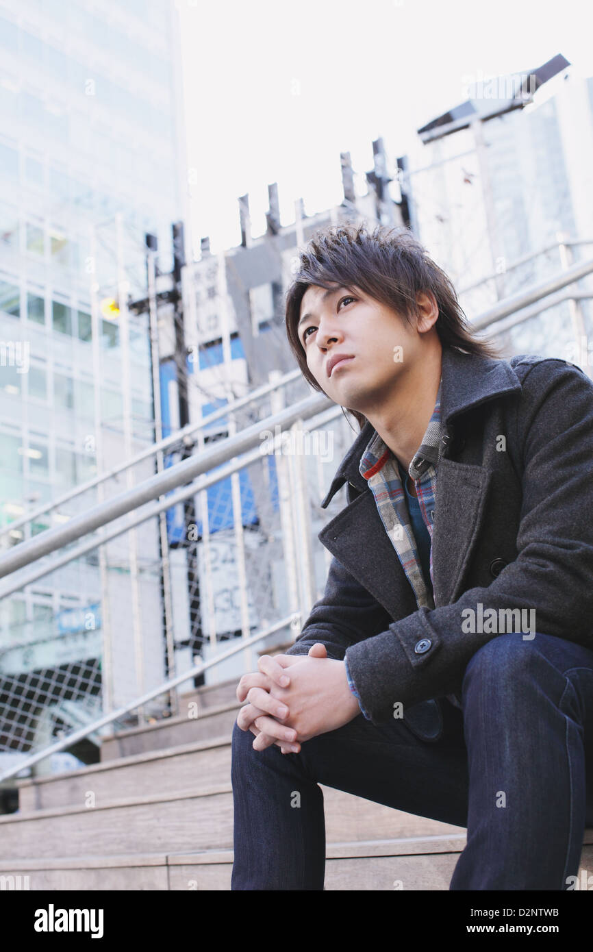 Young man sitting on the stairs Stock Photo - Alamy