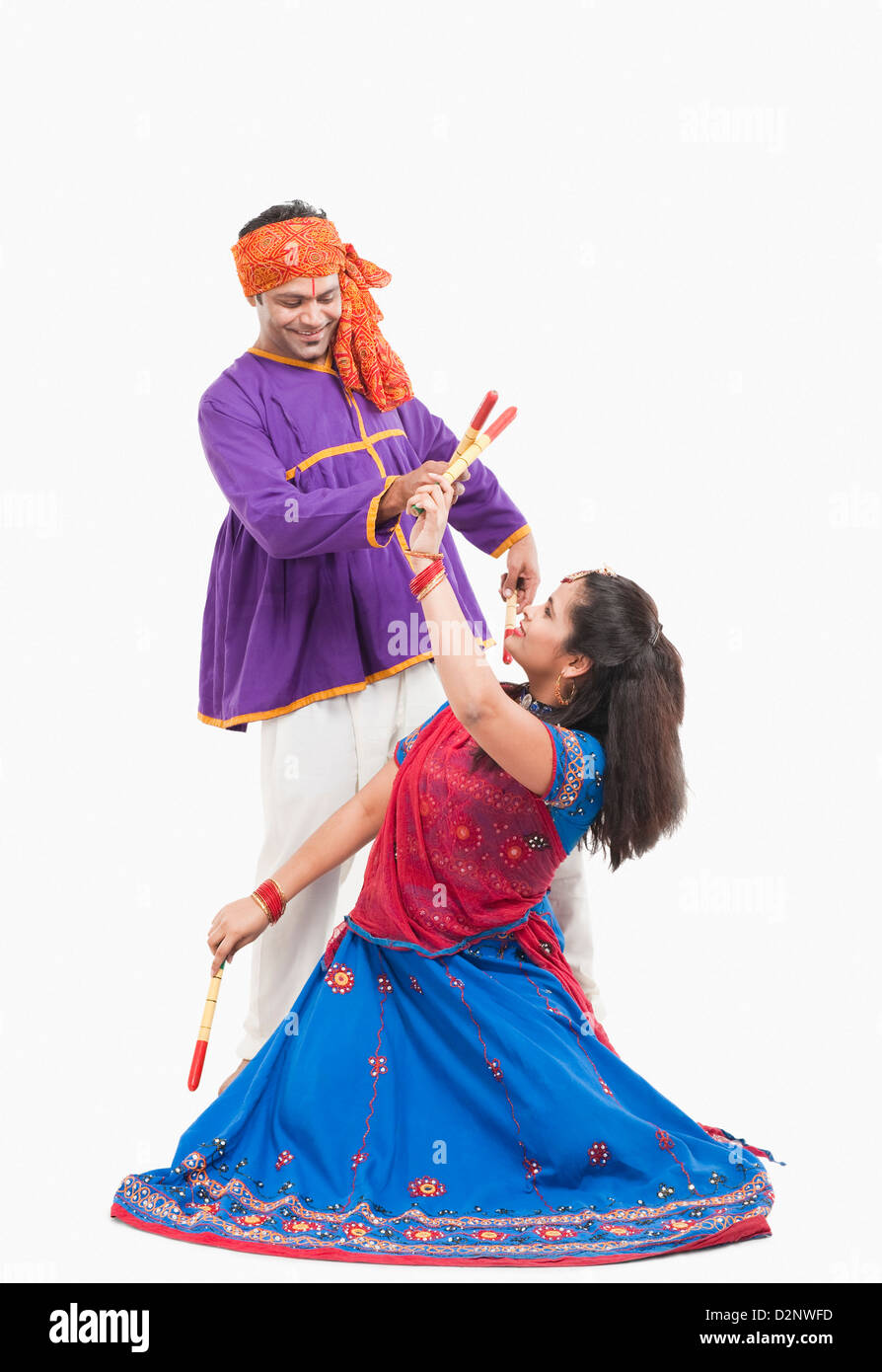 Couple performing dandiya Stock Photo - Alamy