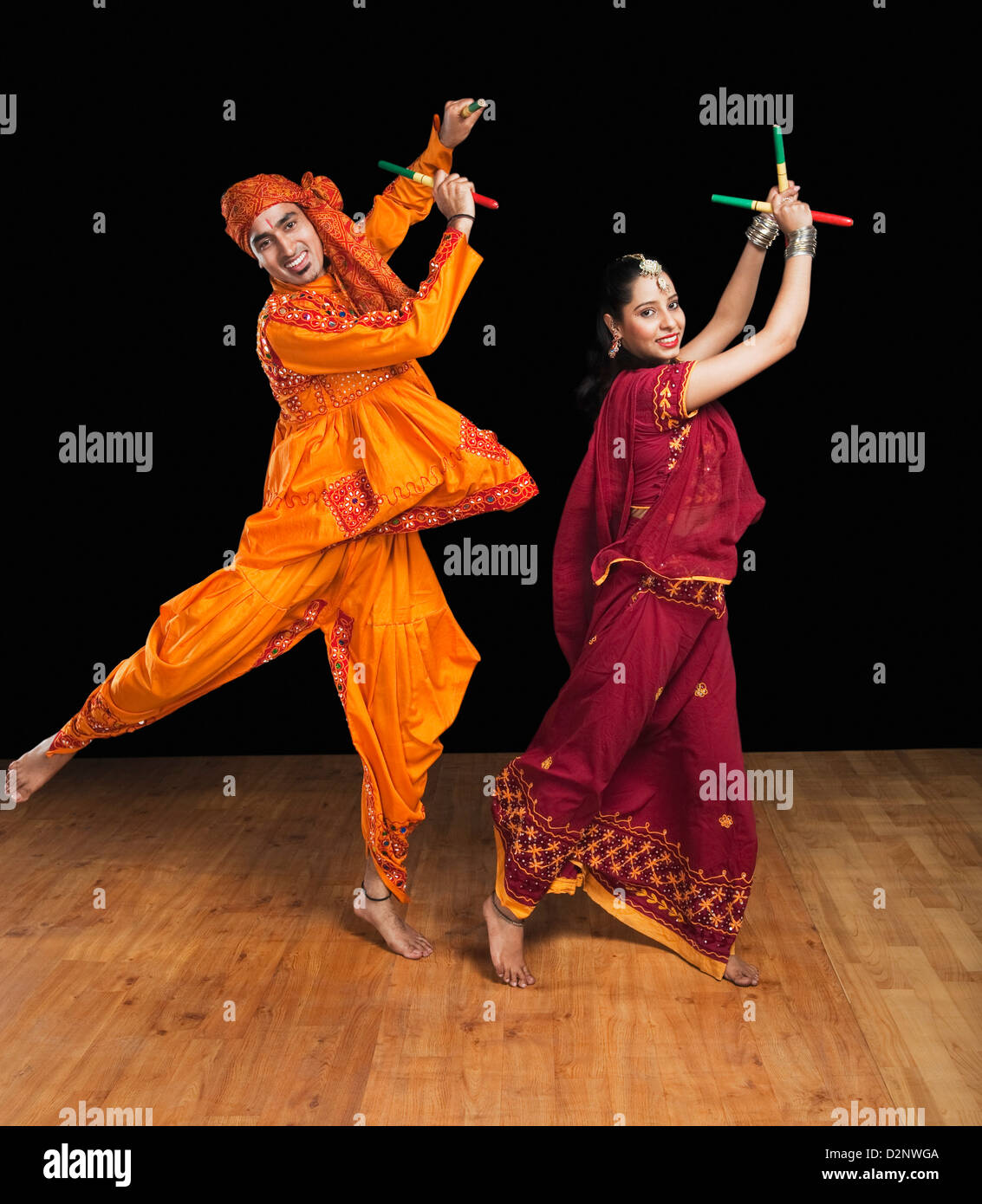 Couple performing dandiya Stock Photo - Alamy