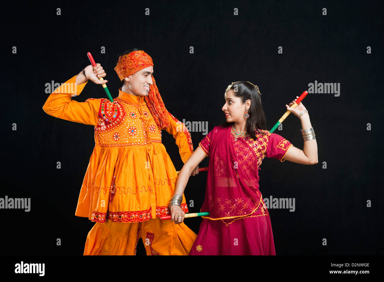 Couple performing dandiya Stock Photo - Alamy
