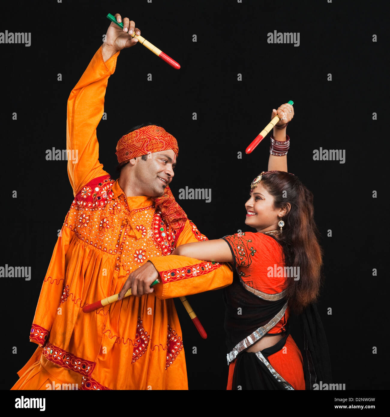 Couple performing dandiya Stock Photo - Alamy