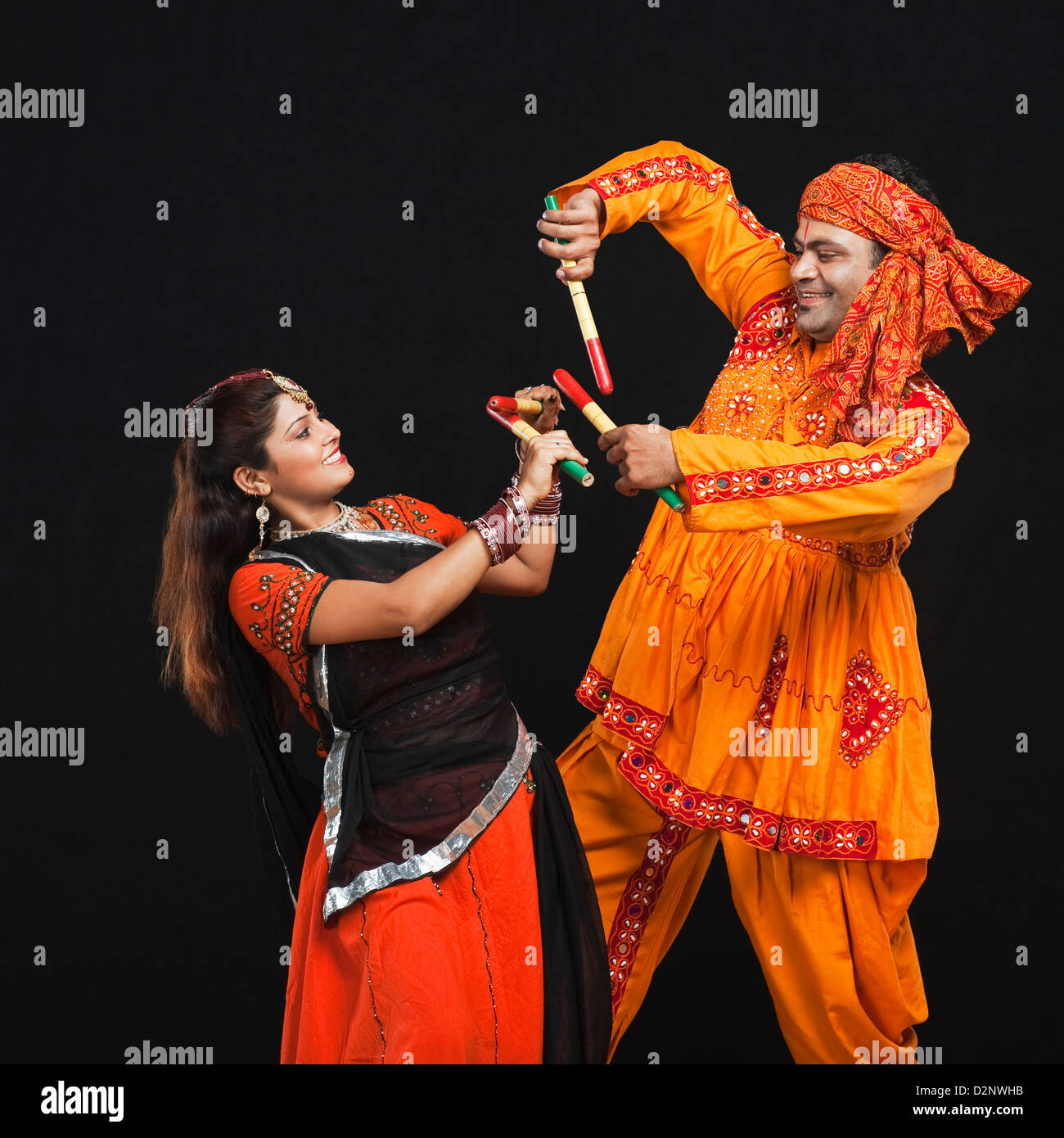 Couple performing dandiya Stock Photo - Alamy