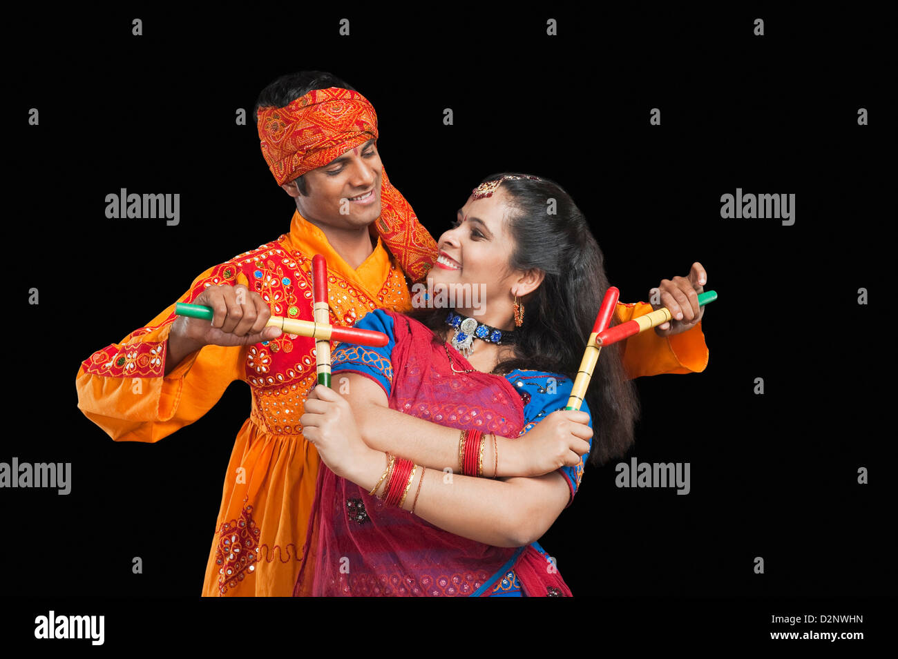 Couple performing dandiya Stock Photo - Alamy