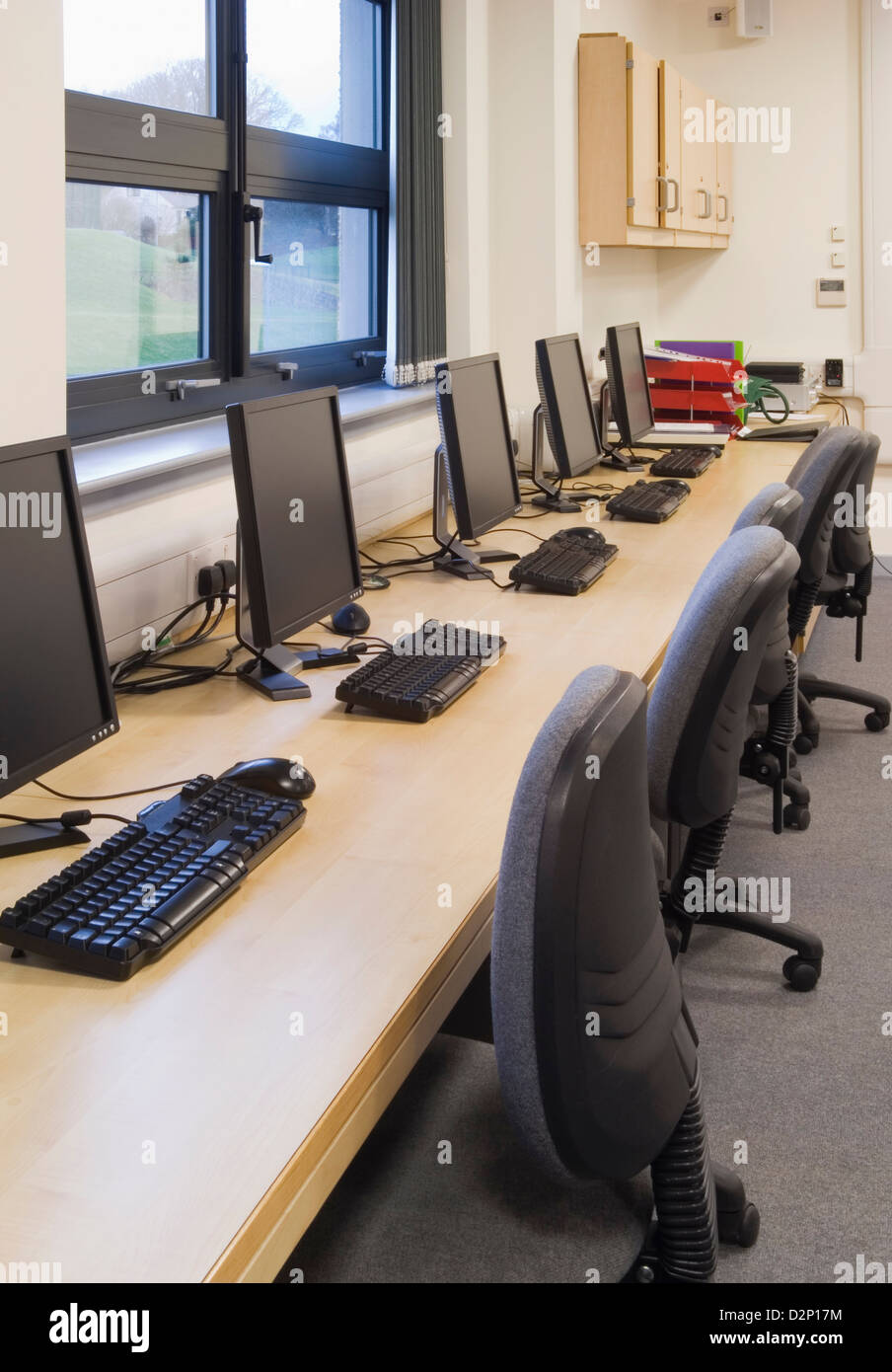 Row of computers and chairs in a classroom of a modern secondary school
