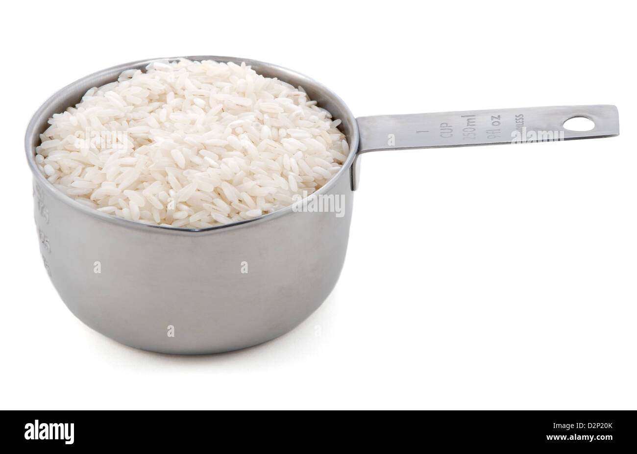 White long grain rice presented in an American metal cup measure, isolated on a white background Stock Photo