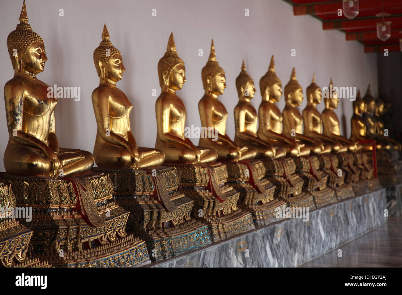 A line of praying Golden Buddhas or a 'Prayer'in a Thai Temple Stock Photo