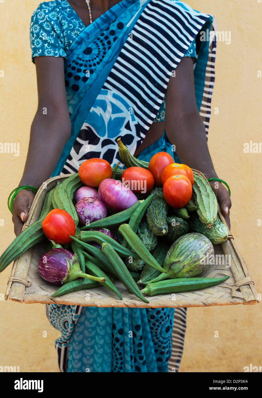 Rural Indian village woman holding a tray of indian vegetables in her hands. Andhra Pradesh, India Stock Photo