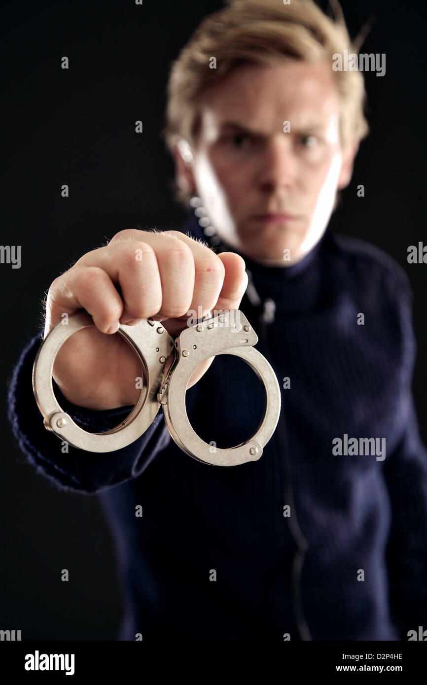 Cop showing handcuffs for those offenders of the law Stock Photo