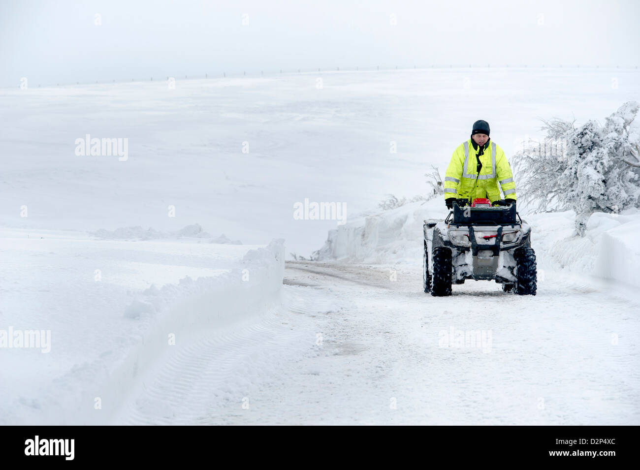A farmer on a quadbike on the A39 Somerset between Porlock and Lynton which was blocked overnight by snowdrifts, UK Stock Photo