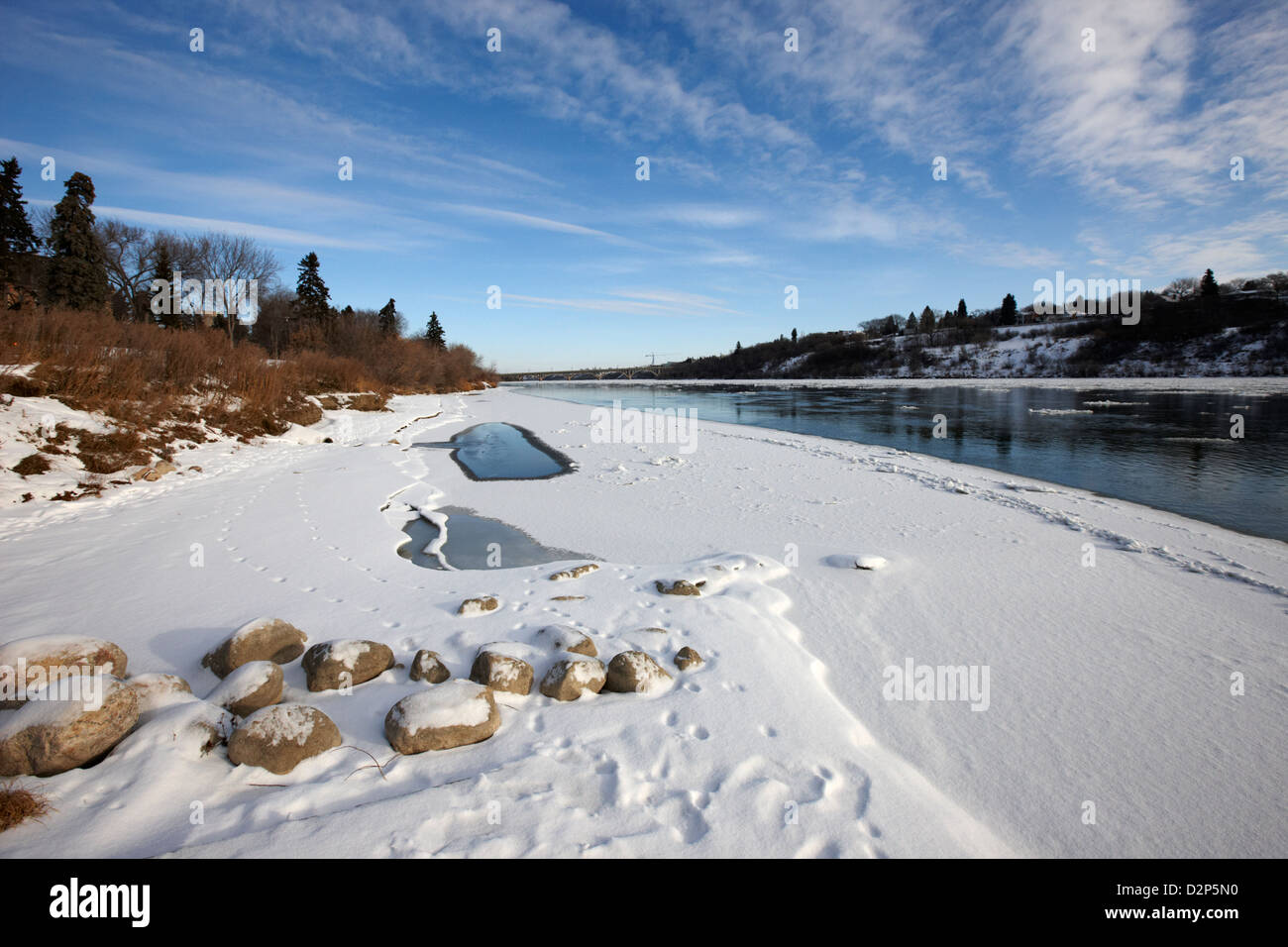 frozen river bank of the south saskatchewan river in winter flowing through downtown Saskatoon Saskatchewan Canada Stock Photo