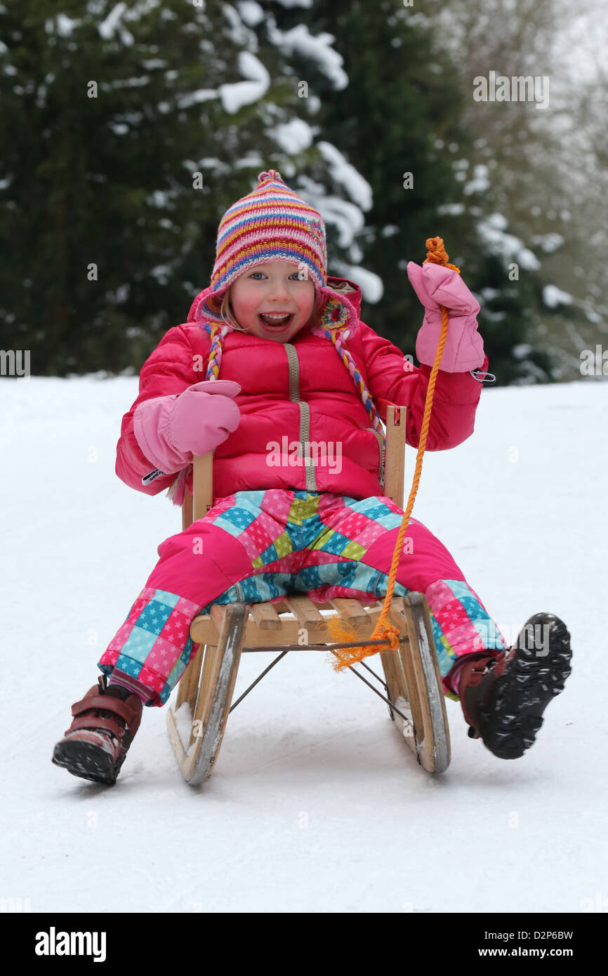 Young girl (4 years) sits on a sled in Dortmund, Germany Stock Photo