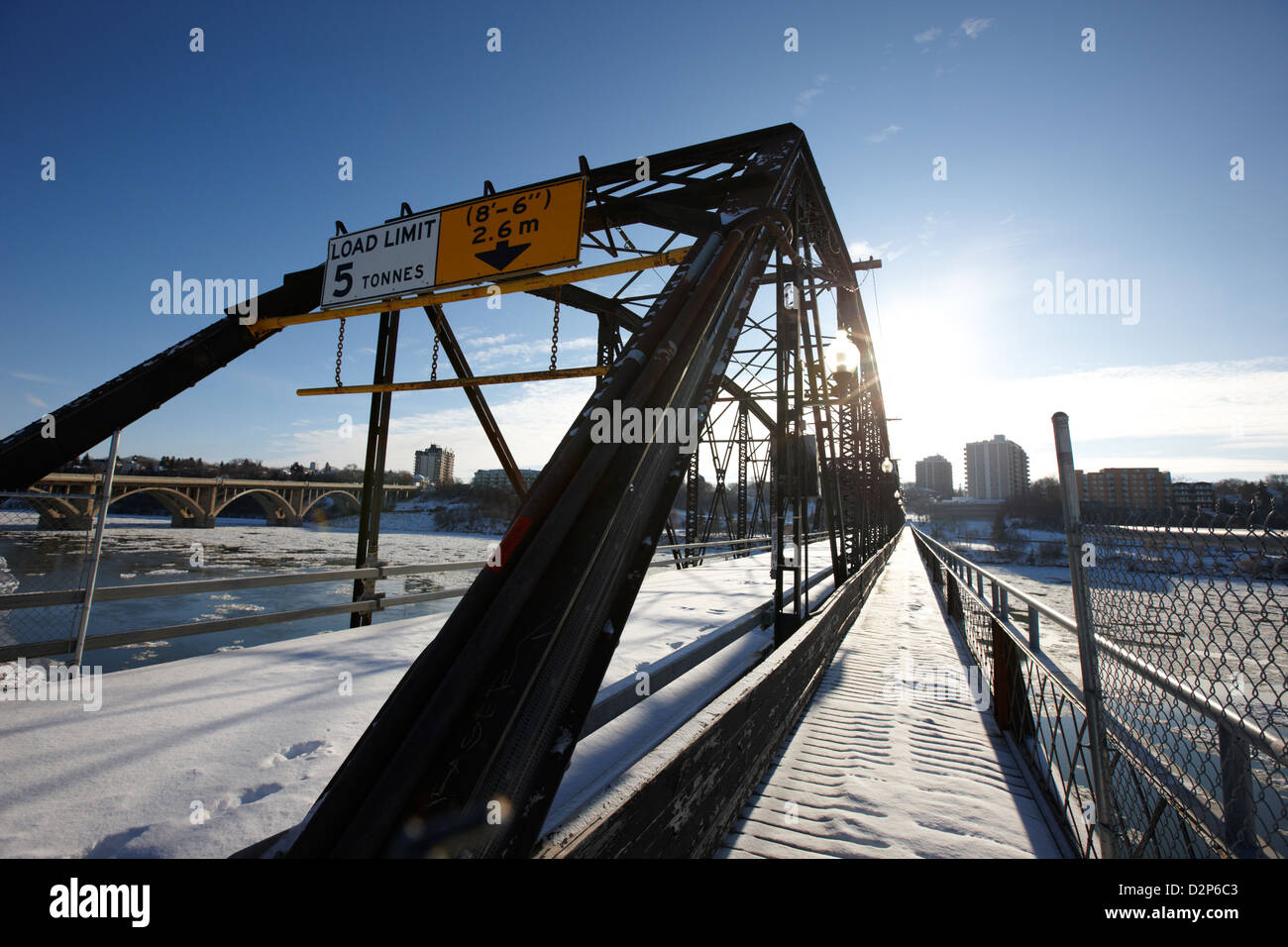 the old traffic bridge over the south saskatchewan river in winter flowing through downtown Saskatoon Saskatchewan Canada Stock Photo