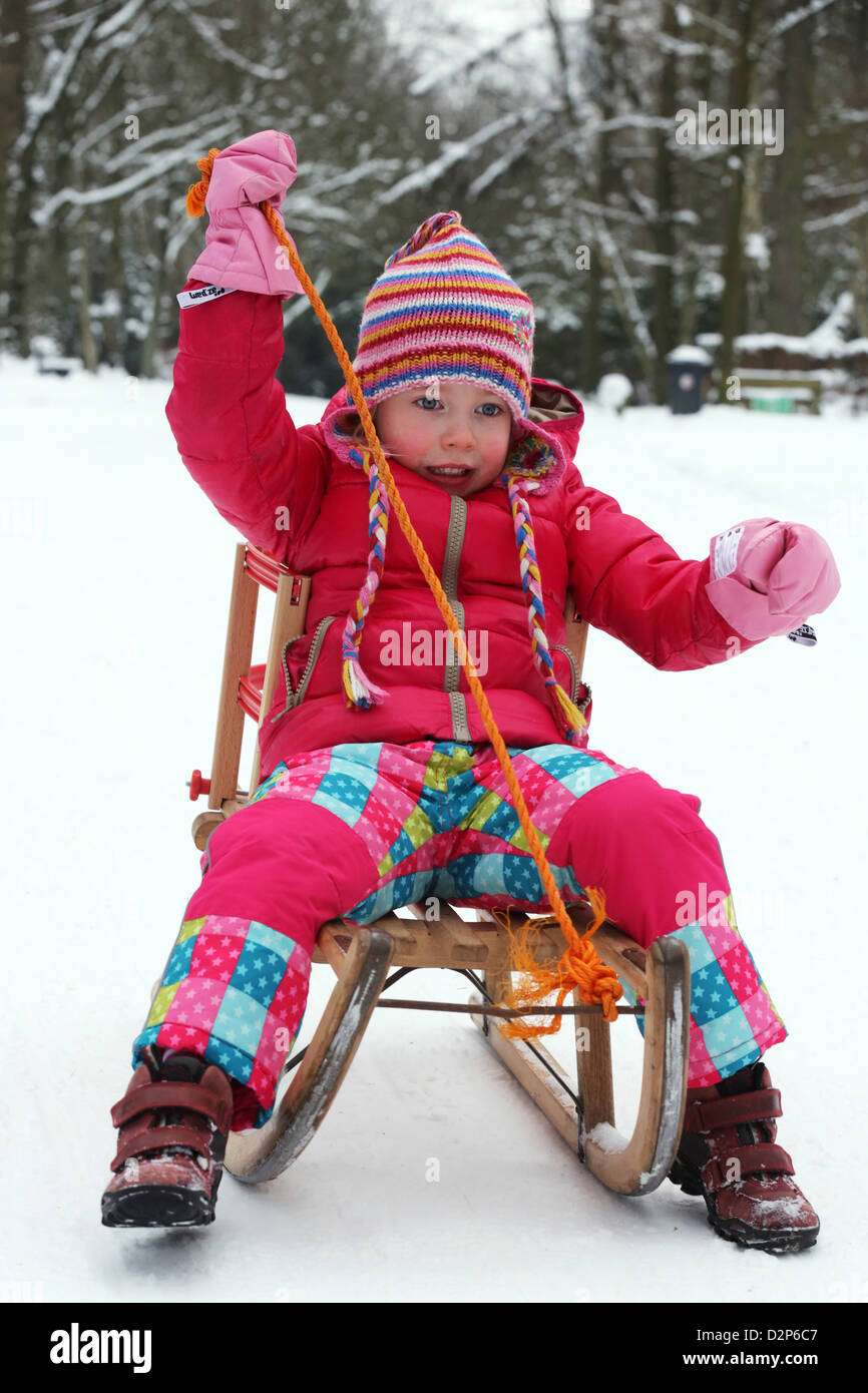 Young girl (4 years) sits on a sled in Dortmund, Germany Stock Photo