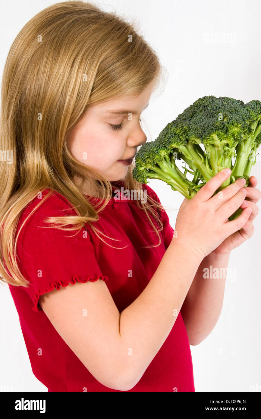 Young healthy girl smelling a head of green broccoli Stock Photo Alamy