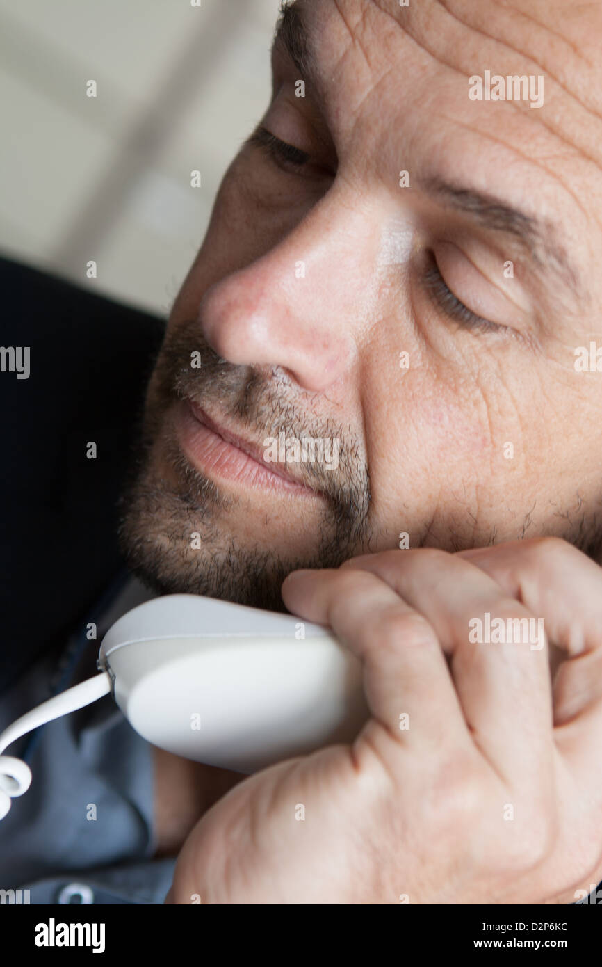 A man using his office phone Stock Photo