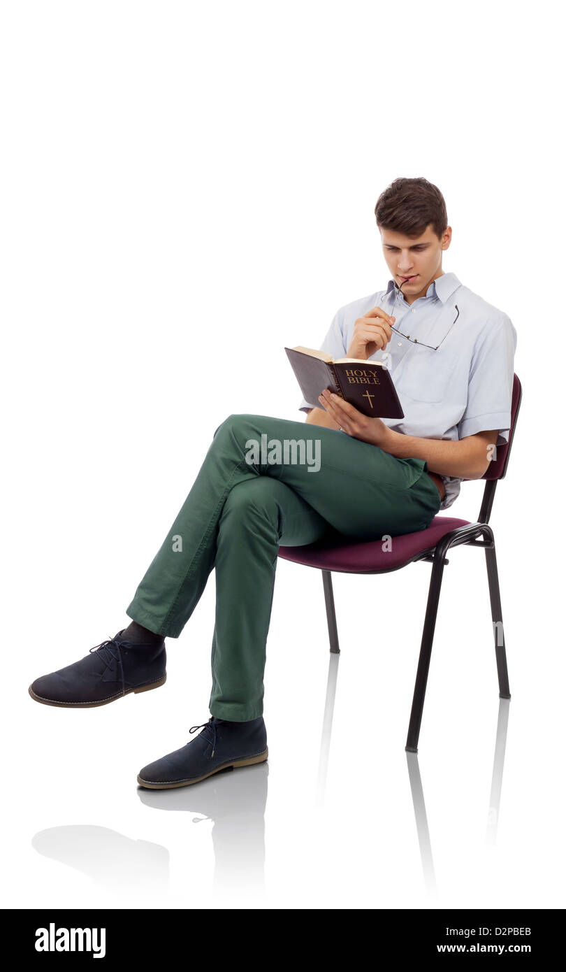 Young christian man sitting and reading Holy Bible Stock Photo