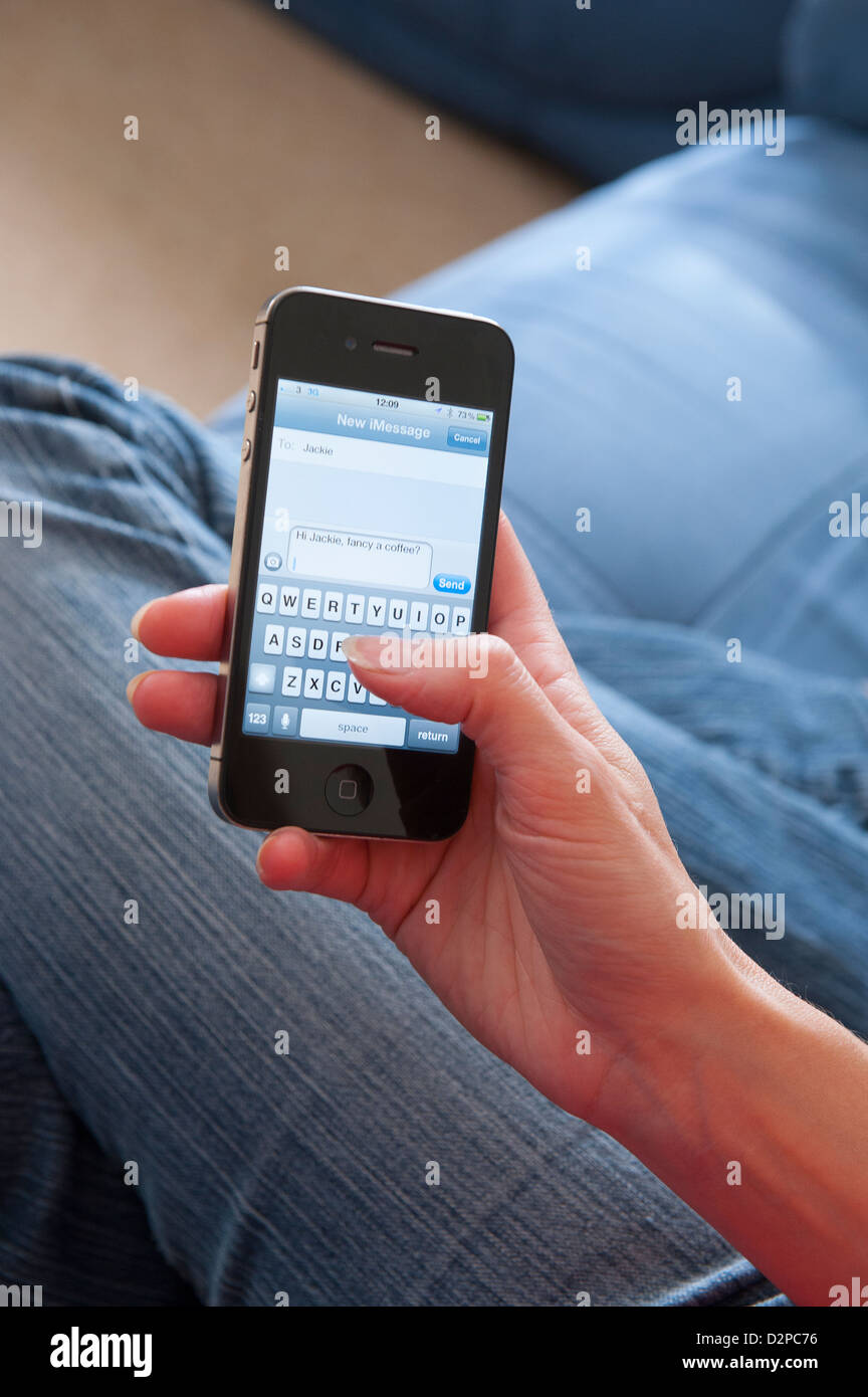 Person sending a text message using an apple iphone stock photo alamy