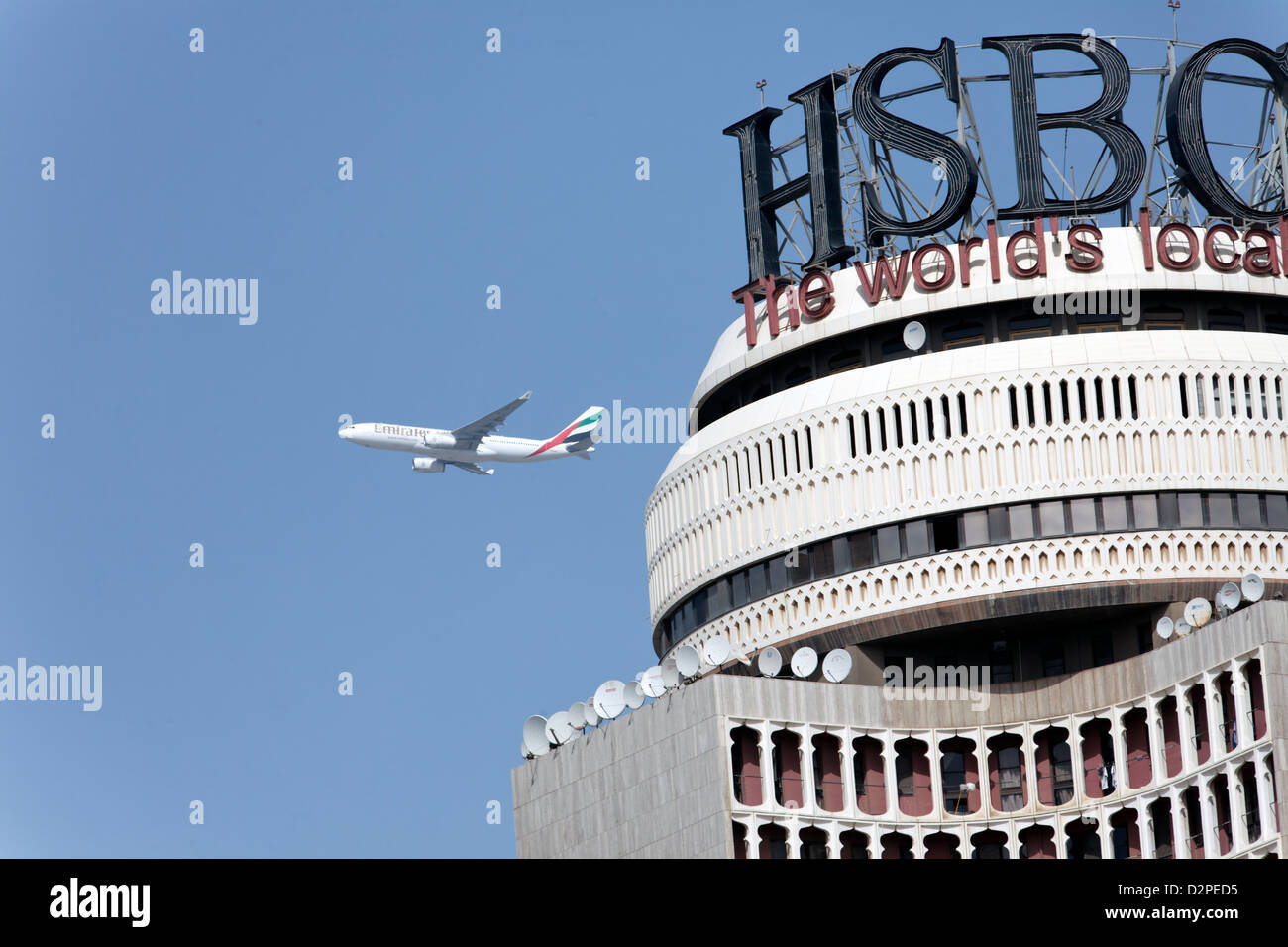 An Emirates Airbus A330 passing the HSBC building on its flight from Dubai Stock Photo