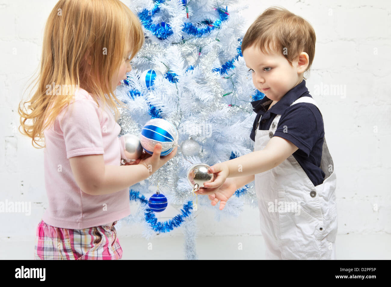 two beautiful happy children decorate christmas tree Stock Photo - Alamy